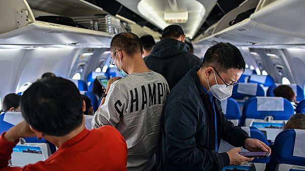 Maszkot viselnek egy Sanghajból Vuhanba tartó járat utasai Maszkot viselnek egy Sanghajból Vuhanba tartó járat utasai