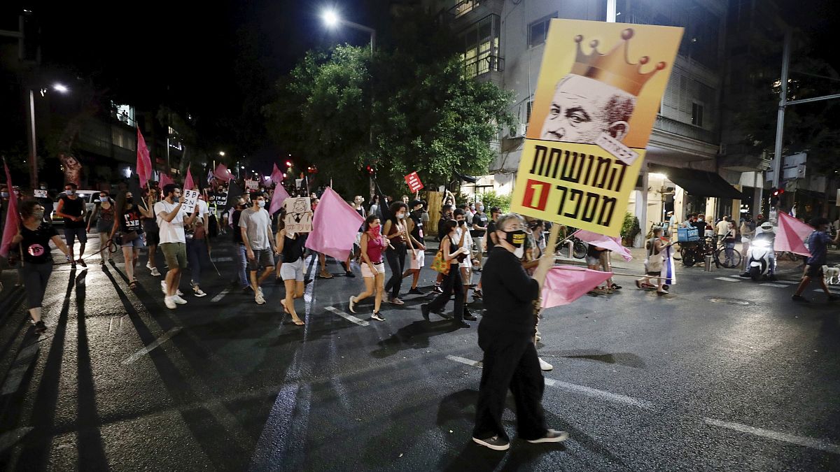 Israeli protesters march on the street during a demonstration against Israeli Prime Minister, Benjamin Netanyahu in Tel Aviv, Israel, Saturday, Oct. 10, 2020.