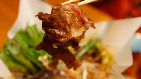 A slice of beef for sukiyaki is picked up by chopsticks at Japanese restaurant Irimoya Bettei in Tokyo