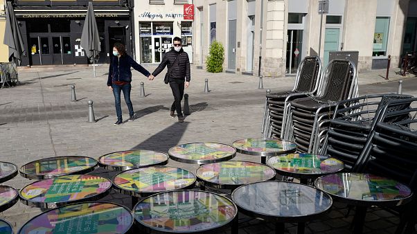 Um casal passa diante de um café encerrado na cidade francesa de Lille Um casal passa diante de um café encerrado na cidade francesa de Lille