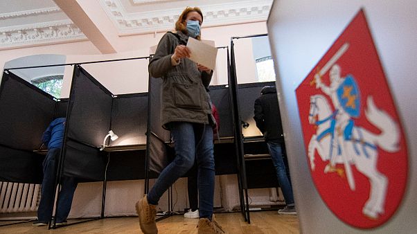 A voter walks past the Lithuanian coat of arms at a polling station during parliamentary elections in Vilnius, Lithuania, Sunday, Oct.11, 2020. A voter walks past the Lithuanian coat of arms at a polling station during parliamentary elections in Vilnius, Lithuania, Sunday, Oct.11, 2020.