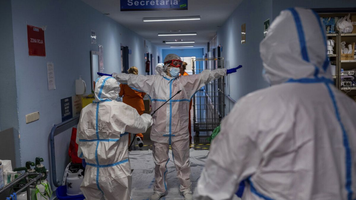FILE - In this Oct. 9, 2020, file photo, a medical team member is disinfected before leaving the COVID-19 ward at a hospital in Leganes, outskirts of Madrid, Spain.