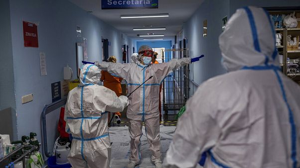 FILE - In this Oct. 9, 2020, file photo, a medical team member is disinfected before leaving the COVID-19 ward at a hospital in Leganes, outskirts of Madrid, Spain. FILE - In this Oct. 9, 2020, file photo, a medical team member is disinfected before leaving the COVID-19 ward at a hospital in Leganes, outskirts of Madrid, Spain.