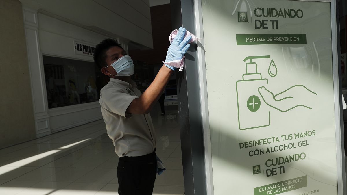 Un hombre desinfecta un panel en el centro comercial Multiplaza de Ciudad de Panamá, 17 de agosto de 2020