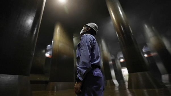 Un operario mira hacia el techo del depósito de Kasukabe Un operario mira hacia el techo del depósito de Kasukabe