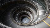 A woman walks down a staircase designed by Giuseppe Momo in 1932, in Vatican Museum