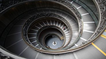 A woman walks down a staircase designed by Giuseppe Momo in 1932, in Vatican Museum