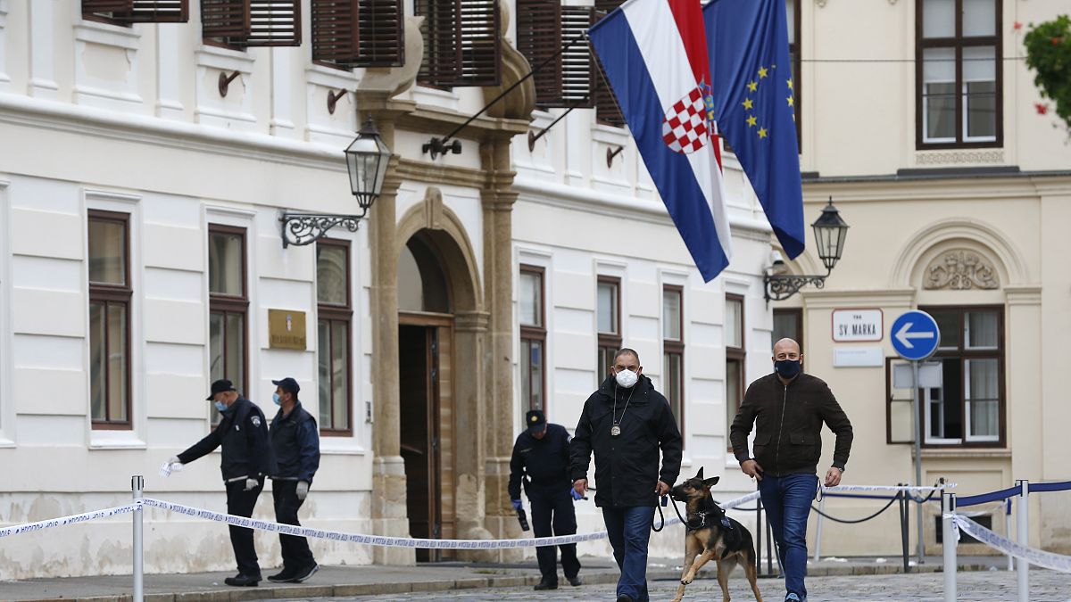 Police officers inspect the site of shooting at St. Mark's Square in Zagreb.