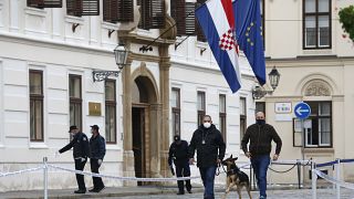 Police officers inspect the site of shooting at St. Mark's Square in Zagreb.