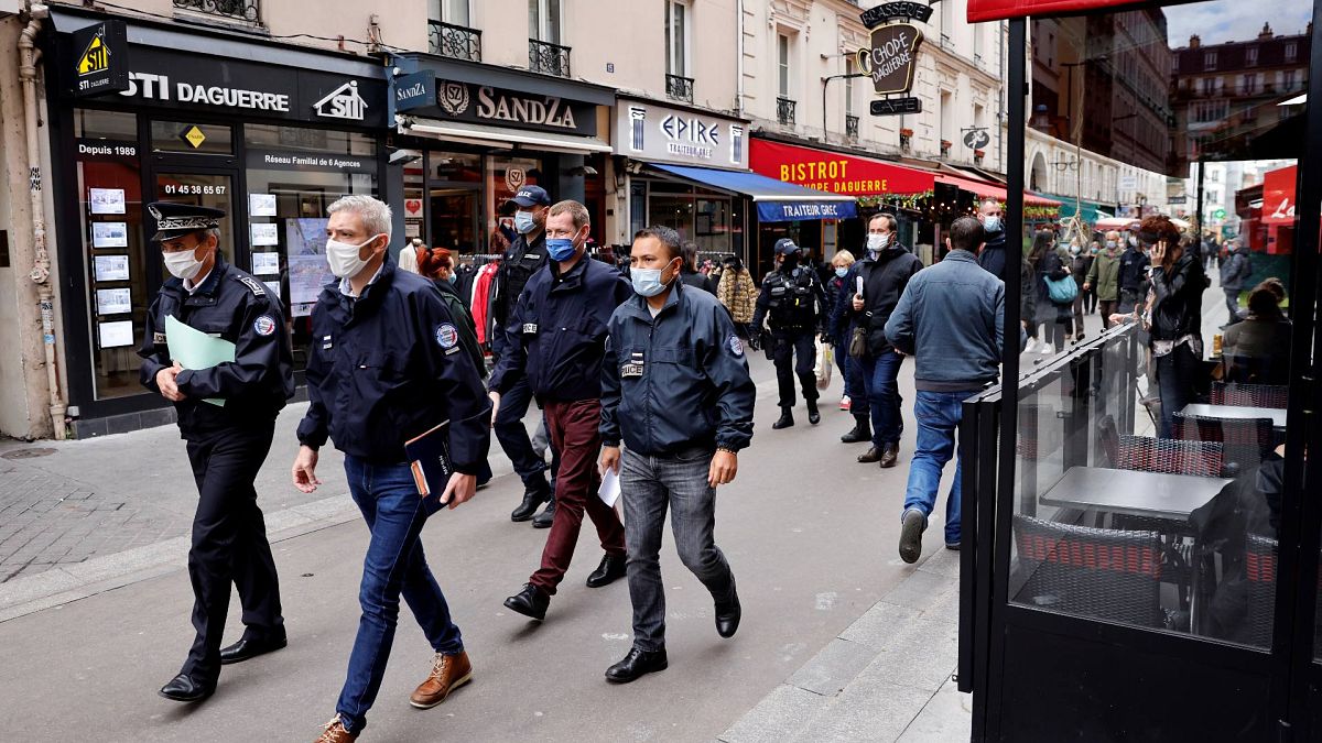 ضباط الشرطة يسيرون في أحد شوارع باريس به مطاعم، خلال دورية لتفقد تنفيذ الإجراءات الصحية الجديدة التي تهدف إلى الحد من انتشار فيروس كورونا المستجد، 6 أكتوبر 2020 