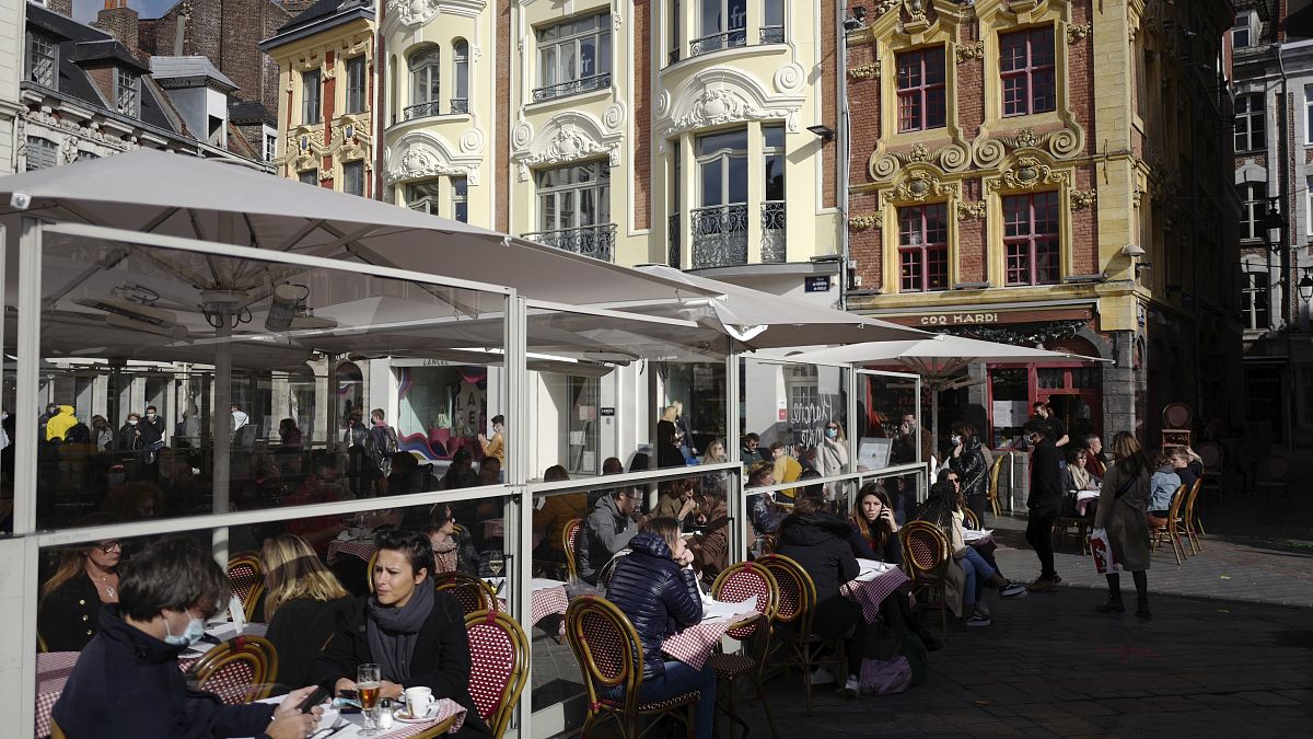 Kávézó teraszán ülő emberek a franciaországi Lille-ben