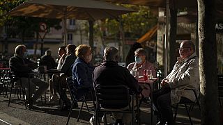 Customers wearing masks to prevent the spread of the coronavirus sit in a terrace bar in Barcelona, Spain,