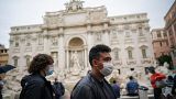 People wear masks by the Trevi Fountain in Rome
