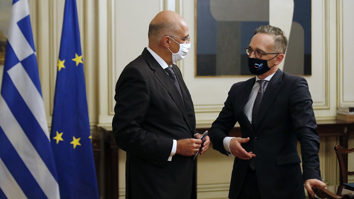 Germany's foreign minister Heiko Maas, right, speaks with his Greek counterpart Nikos Dendias 