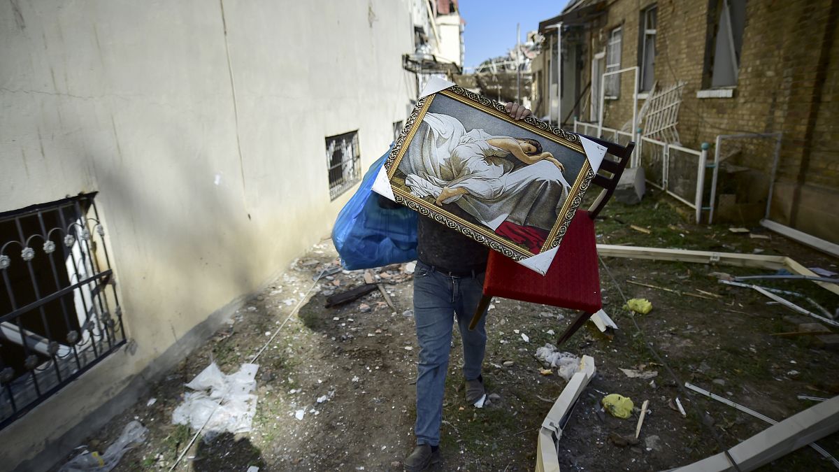 Ateşkes sonrası Gence kentine düzenlenen top atışında yıkılan evini terkeden bir Azeri