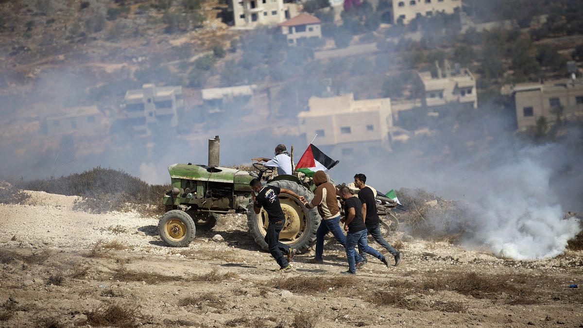 فلسطينيون بالقرب من نابلس يبتعدون عن قنابل مسيلة للدموع أطلقها عليهم الجيش الإسرائيلي 