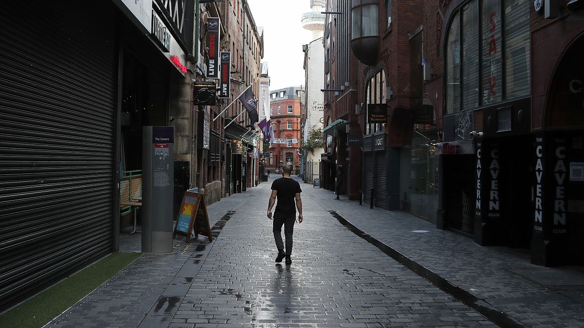Un homme seul marche dans une rue de Liverpool, où tous les pubs sont fermés, Angleterre, le 14 octobre 2020