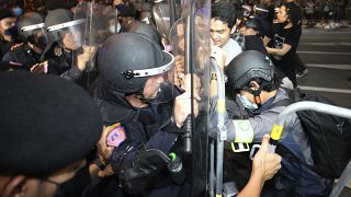 Pro-democracy protesters push Thai policemen with riot shields during a demonstration in Bangkok, Thailand, Thursday, Oct. 15, 2020.