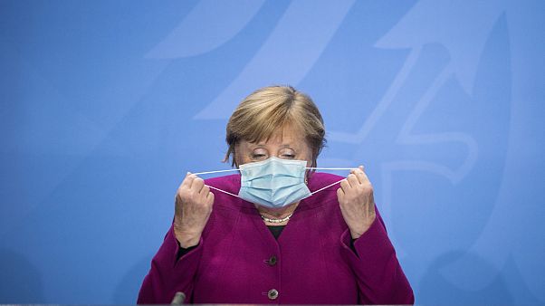 German Chancellor Angela Merkel holds her face mask as she arrives for a press conference after a meeting with the governors of the German states in Berlin, Oct. 14, 2020. German Chancellor Angela Merkel holds her face mask as she arrives for a press conference after a meeting with the governors of the German states in Berlin, Oct. 14, 2020.