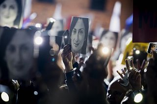 People hold pictures of slain journalist Daphne Caruana Galizia as they protest outside the office of the Maltese Prime Minister Joseph Muscat on Nov. 29, 2019.