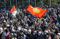 Protesters react waving Kyrgyz national flags as they wait in front of the government building in Bishkek, Kyrgyzstan.