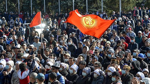 Protesters react waving Kyrgyz national flags as they wait in front of the government building in Bishkek, Kyrgyzstan. Protesters react waving Kyrgyz national flags as they wait in front of the government building in Bishkek, Kyrgyzstan.