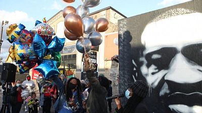 People gather at George Floyd's memorial to celebrate his birthday