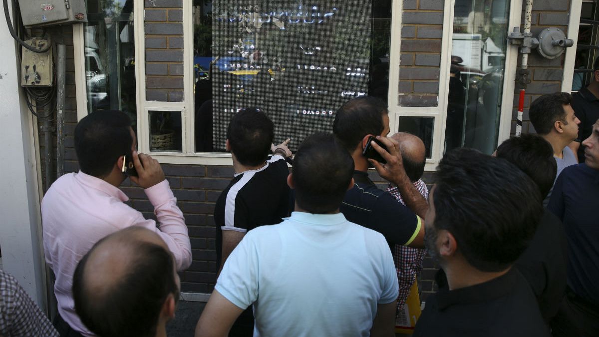 تجمع متقاضیان ارز در مقابل تابلوی نرخ‌های یک صرافی در تهران