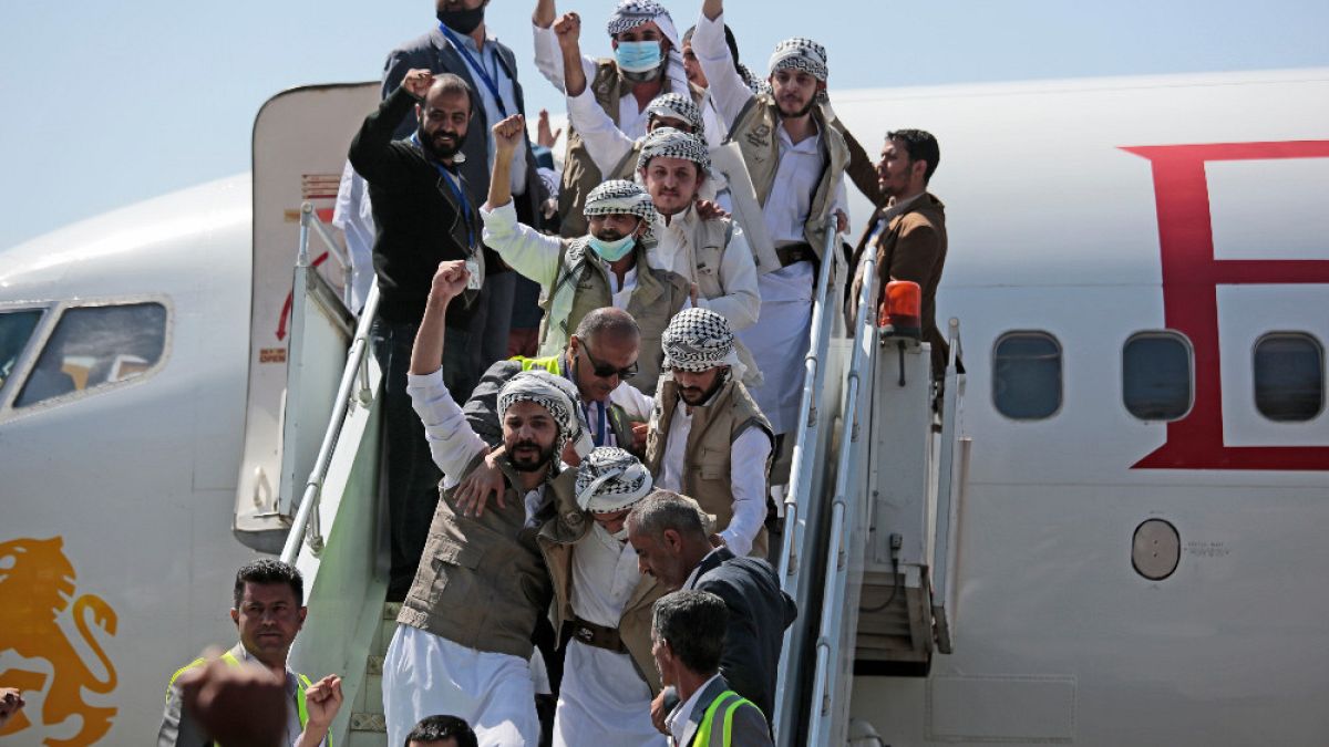 Prigionieri Huthi festeggiano, dopo essere stati liberati dalla coalizione guidata dall'Arabia Saudita, all'aeroporto di Sanaa, Yemen