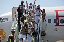 Prigionieri Huthi festeggiano, dopo essere stati liberati dalla coalizione guidata dall'Arabia Saudita, all'aeroporto di Sanaa, Yemen