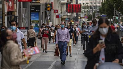 Pedestrians wearing face masks to prevent the spread of coronavirus walk in downtown Madrid, Spain