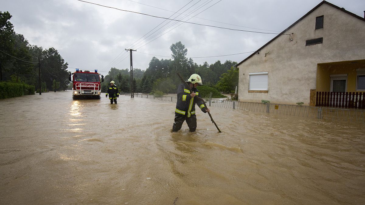 Foto de archivo: los bomberos se abren paso en una calle inundada por el agua en Liszo, Hungría, el 25 de julio de 2020.
