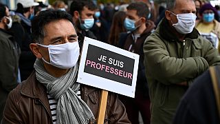 Paris'te saldırıya tepki gösteren bir vatandaş, "Ben öğretmenim" yazan bir pankart taşıyor.