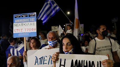 Eine griechische Zyprerin hält ein Plakat mit der Aufschrift "Erinnerung" hoch