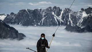 Un skieur porte un masque sur une remontée mécanique dans la station des 2 Alpes, le 17 octobre 2020