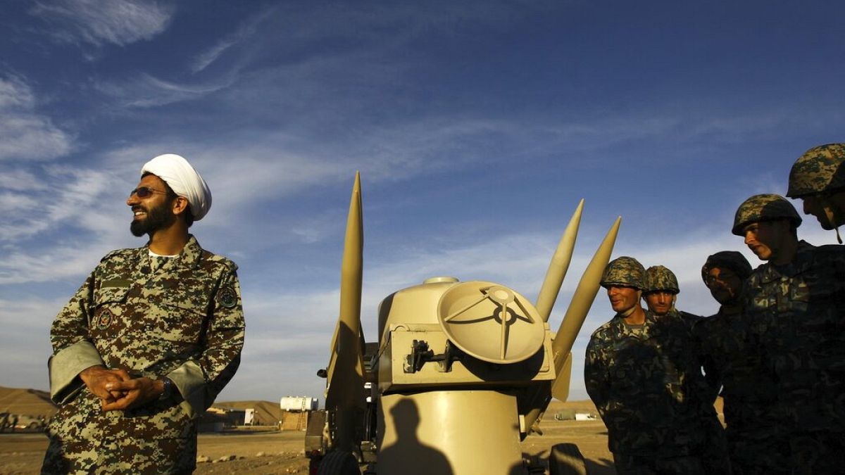  In this Nov. 13, 2012 file photo, an Iranian clergyman stands next to missiles and army troops, during a manoeuvre, in an undisclosed location in Iran.