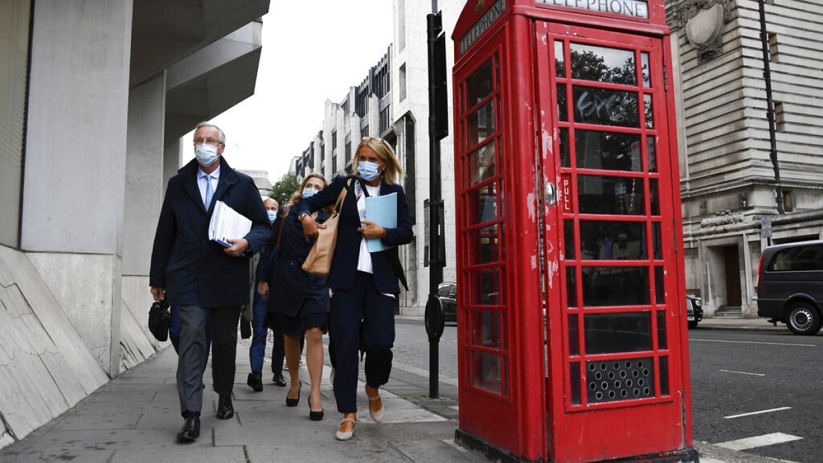 Chief EU negotiator Michel Barnier, left, makes his way to the Department for Business, Energy & Industrial Strategy, in London, Wednesday, Sept. 23, 2020. 