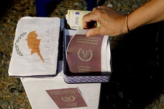 A demonstrator takes a mock copy of Cyprus passport during a demonstration against corruption outside of the conference center in the capital Nicosia, Cyprus, in 2020.
