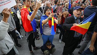 People shout slogans during a protest against the use of face masks and the protection measures against the COVID-19 infections in Bucharest, Romania, Saturday, Oct. 10, 2020