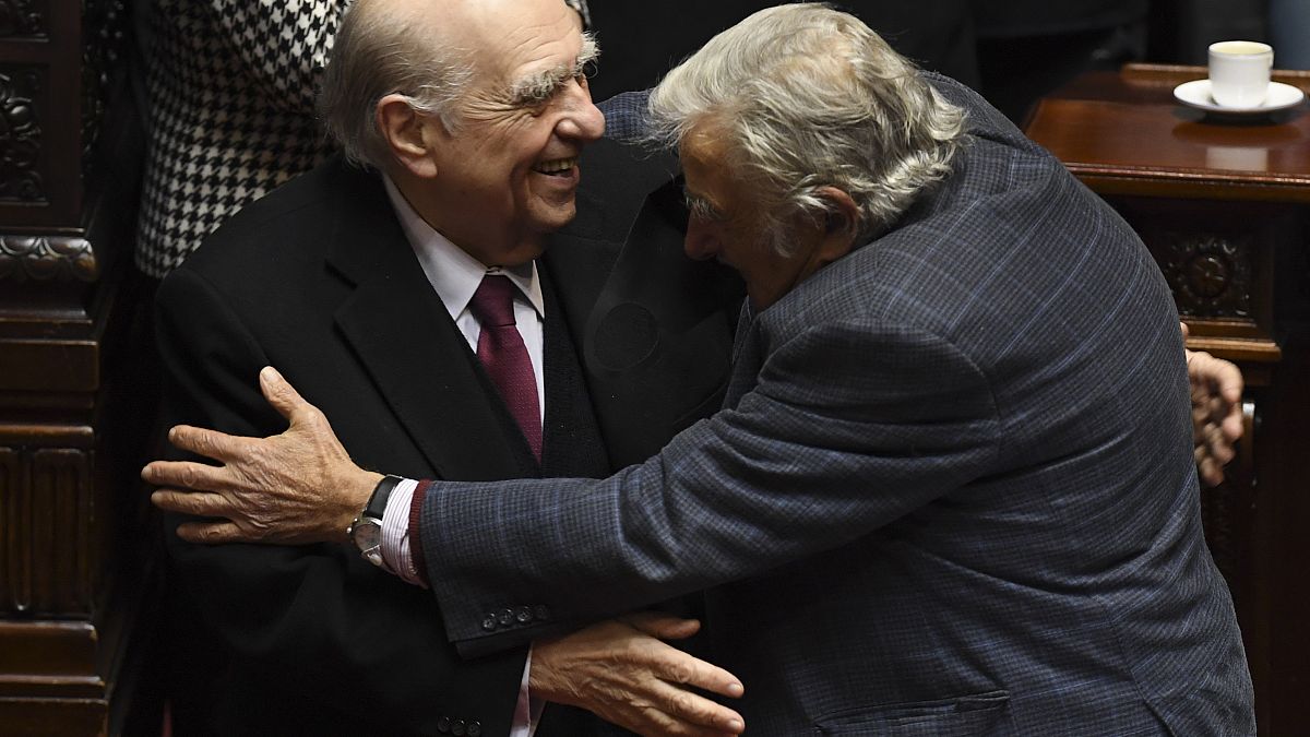 Los expresidentes uruguayos José Mujica y Julio María Sanguinetti se abrazan el día de su adiós político