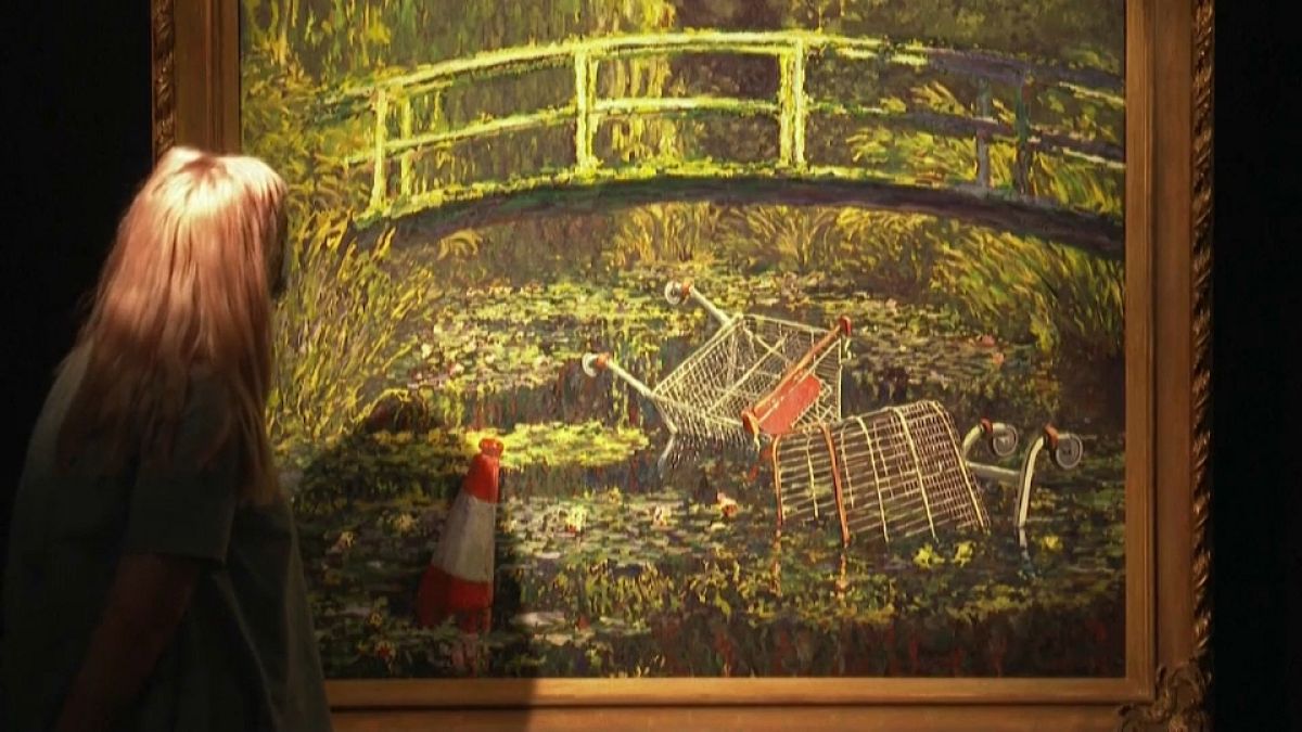امراة تتأمل في لوحة زيتية لبانسكي في مزاد في لندن. 2020/10/20