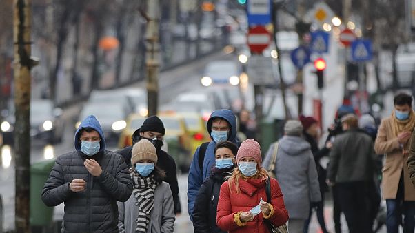 People walk wearing masks during an anti-pollution protest outside the city hall in Bucharest, Romania, Wednesday, Dec. 12, 2018. People walk wearing masks during an anti-pollution protest outside the city hall in Bucharest, Romania, Wednesday, Dec. 12, 2018.
