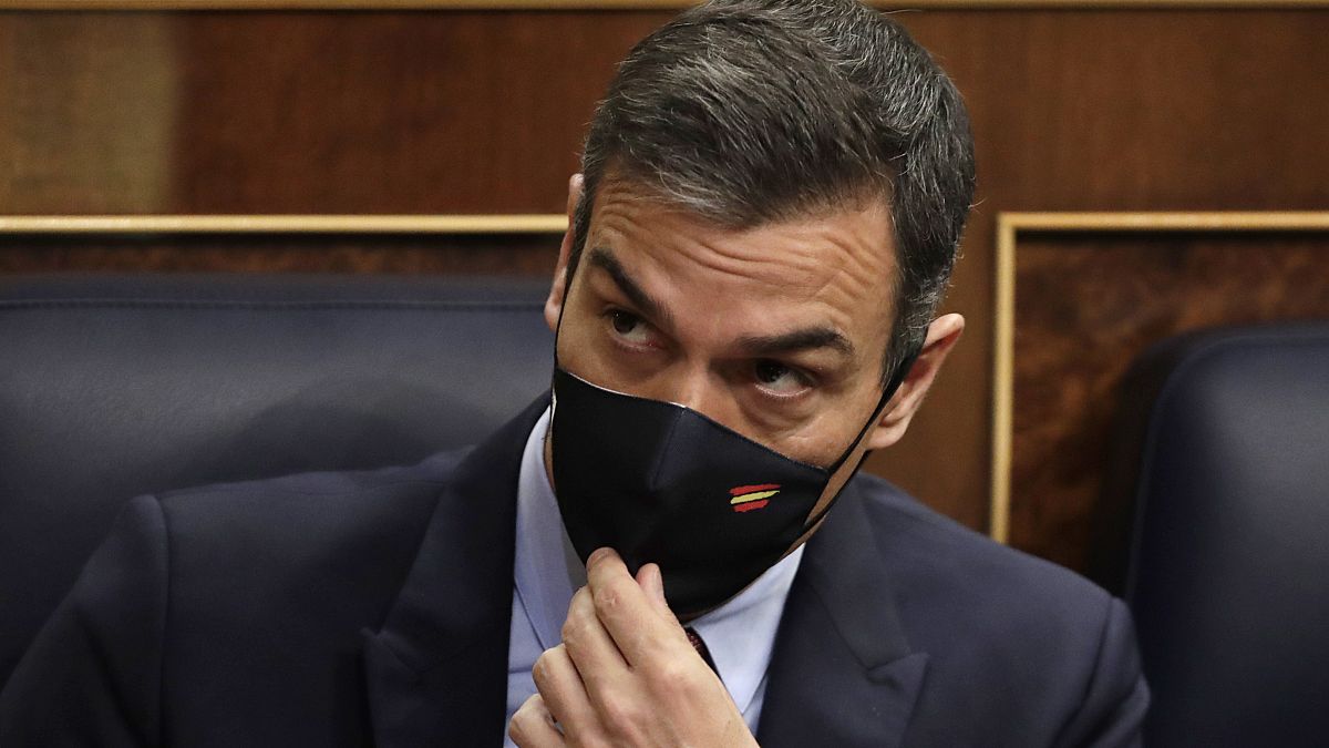 Spain's Prime Minister Pedro Sanchez adjusts his face mask at a parliamentary session ahead of a no-confidence vote. Madrid, Spain. October 21, 2020.