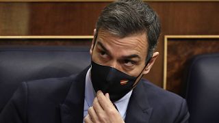 Spain's Prime Minister Pedro Sanchez adjusts his face mask at a parliamentary session ahead of a no-confidence vote. Madrid, Spain. October 21, 2020.