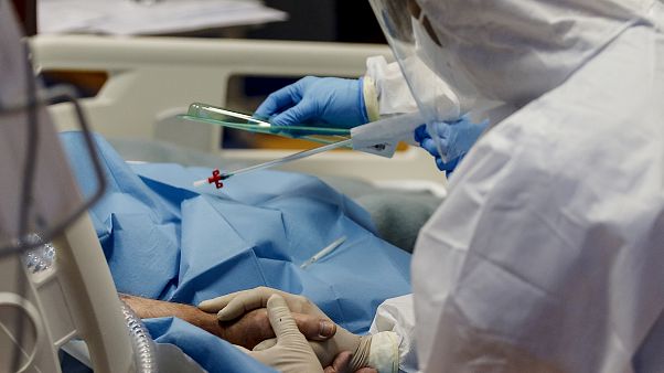 Une infirmière tient la main d'un patient atteint du Covid-19 dans l'unité de soins intensifs de l'hôpital Casal Palocco à Rome Mardi 20 octobre 2020 Une infirmière tient la main d'un patient atteint du Covid-19 dans l'unité de soins intensifs de l'hôpital Casal Palocco à Rome Mardi 20 octobre 2020