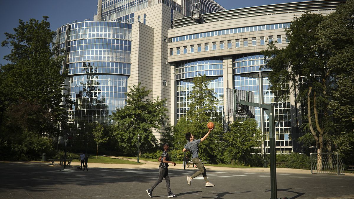 Youngsters play basketball in front of the European Parliament building in Brussels, Wednesday, May 15, 2019.