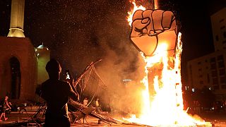 A protester takes pictures of a protest symbol that was set on fire by the supporters of former Lebanese Prime Minister Saad Hariri, Oct 21 2020