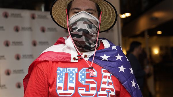 Un joven latino asiste envuelto en una bandera estadounidense a uno de los debates de "Latinos for Trump" Un joven latino asiste envuelto en una bandera estadounidense a uno de los debates de "Latinos for Trump"