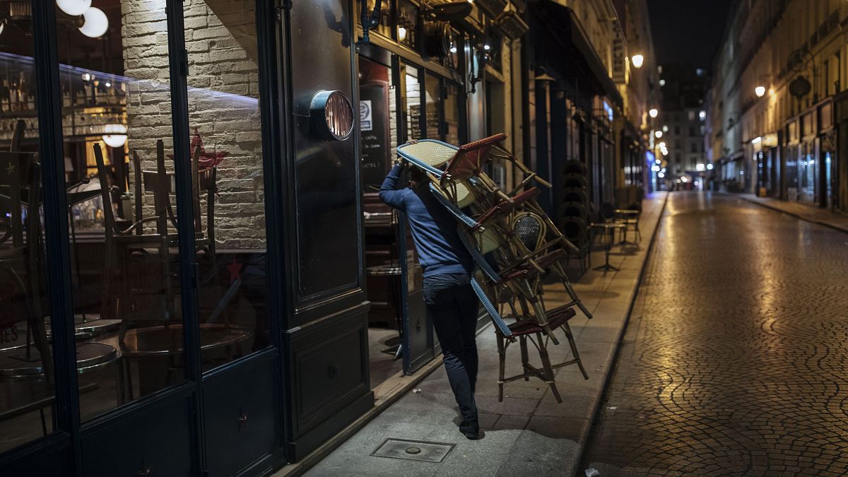 A waiter closes a bar terrace in Paris, Saturday, Oct. 17, 2020.