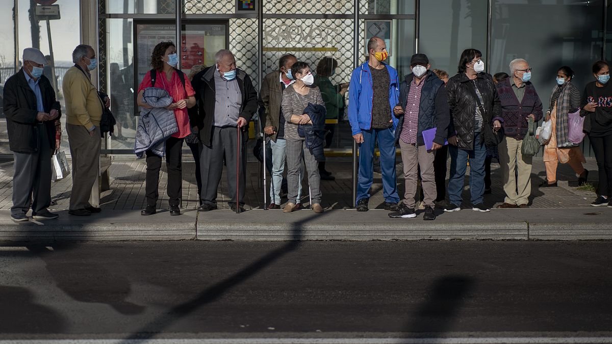 People wearing masks wait for a bus in Barcelona. Spain has reported over a million cases of COVID-19